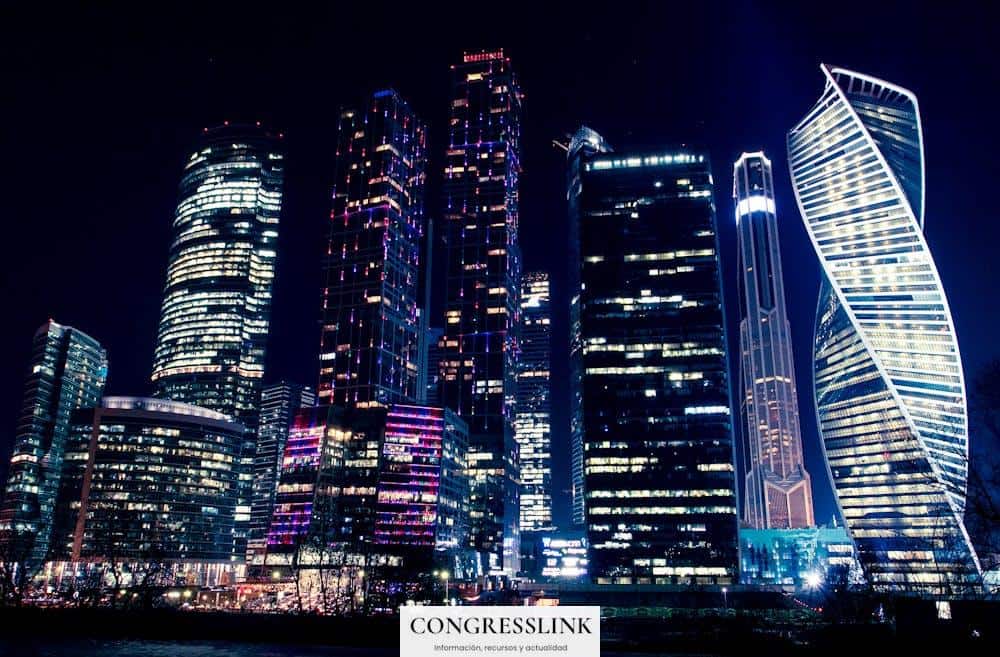 Illuminated night view of Moscow's modern skyscrapers, showcasing vibrant city lights and urban architecture.